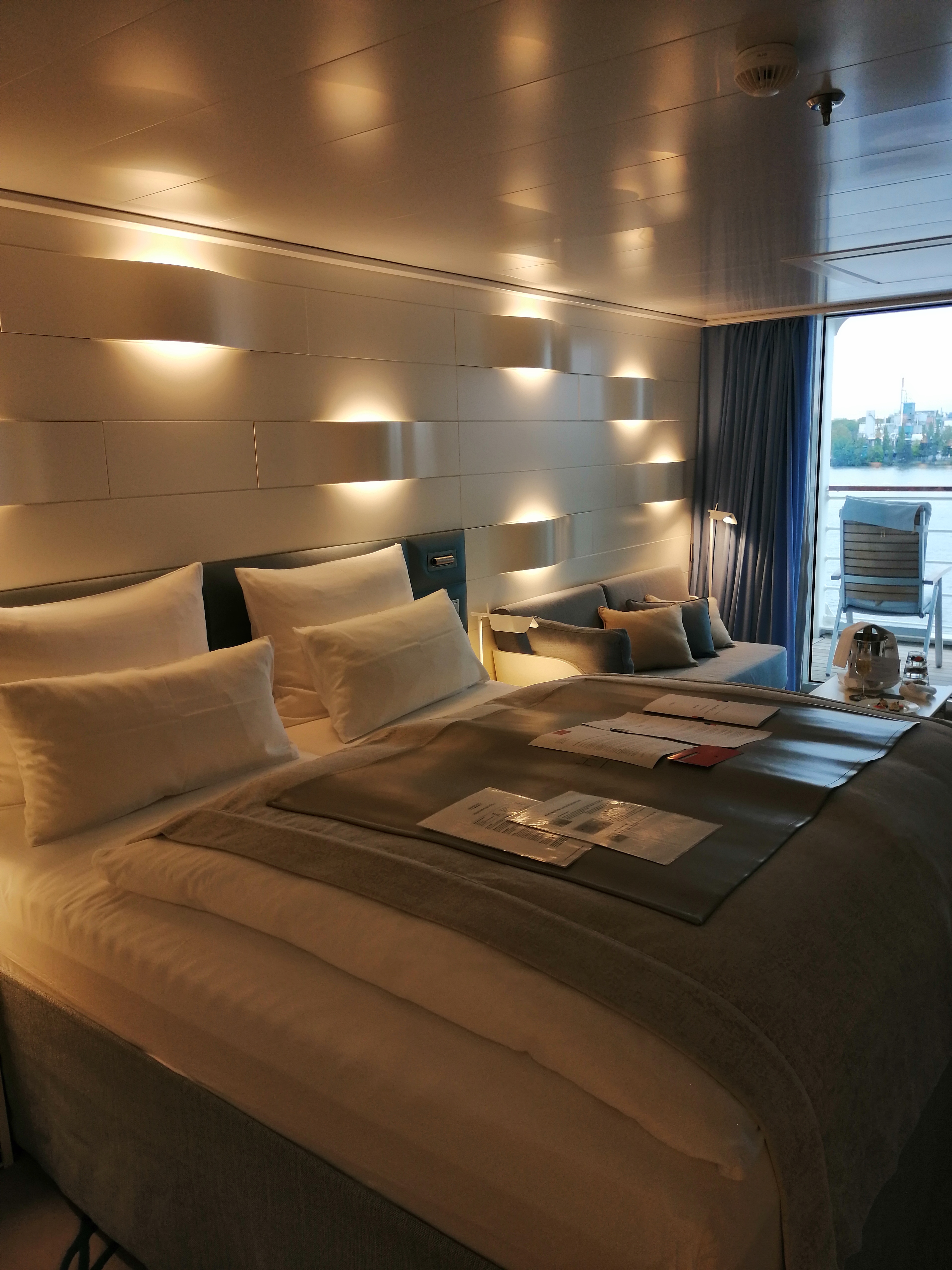 Moderne Kabine mit Doppelbett und indirekter Beleuchtung auf einem Kreuzfahrtschiff