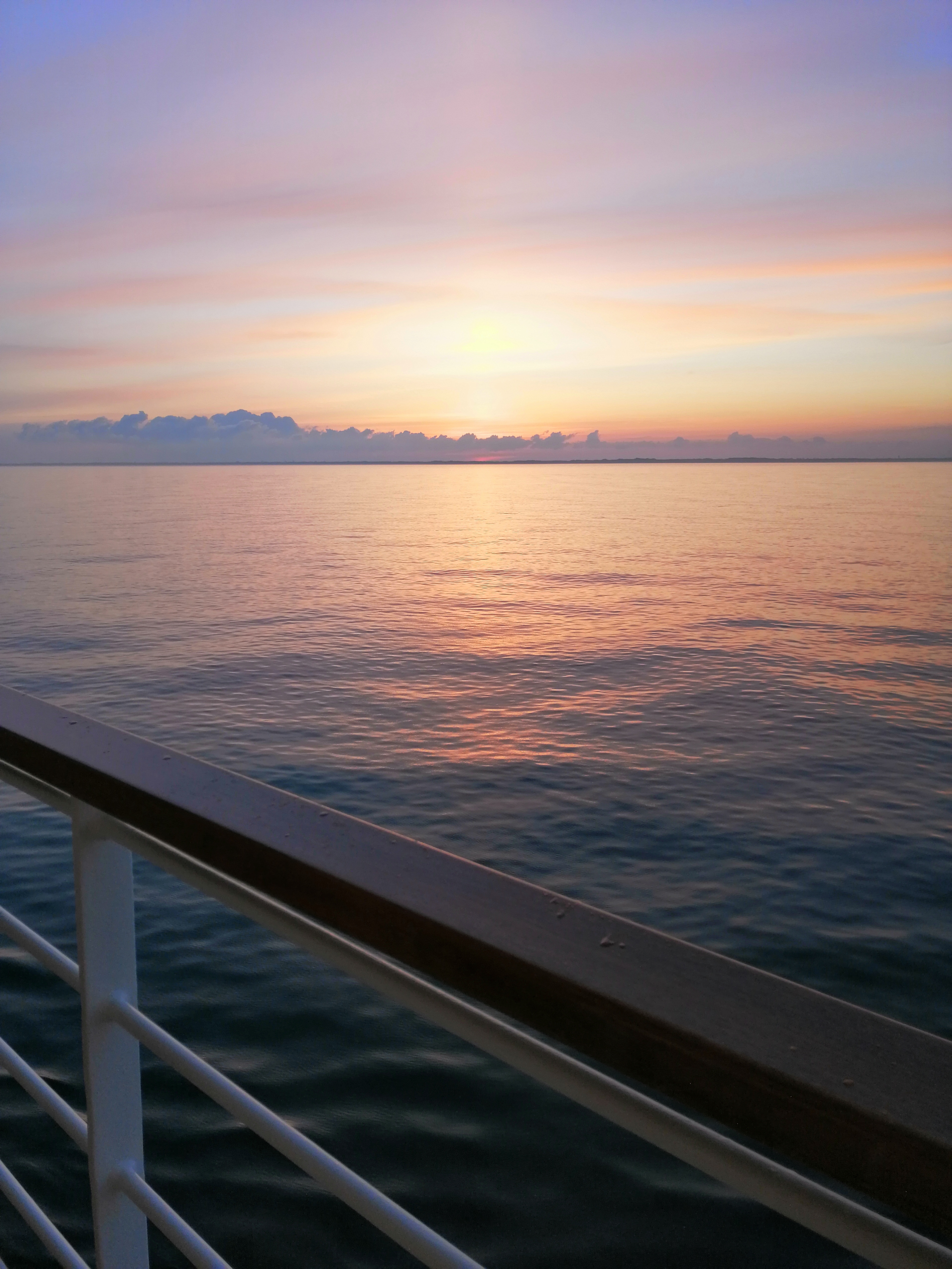 Sonnenuntergang über dem Meer vom Deck eines Kreuzfahrtschiffs aus