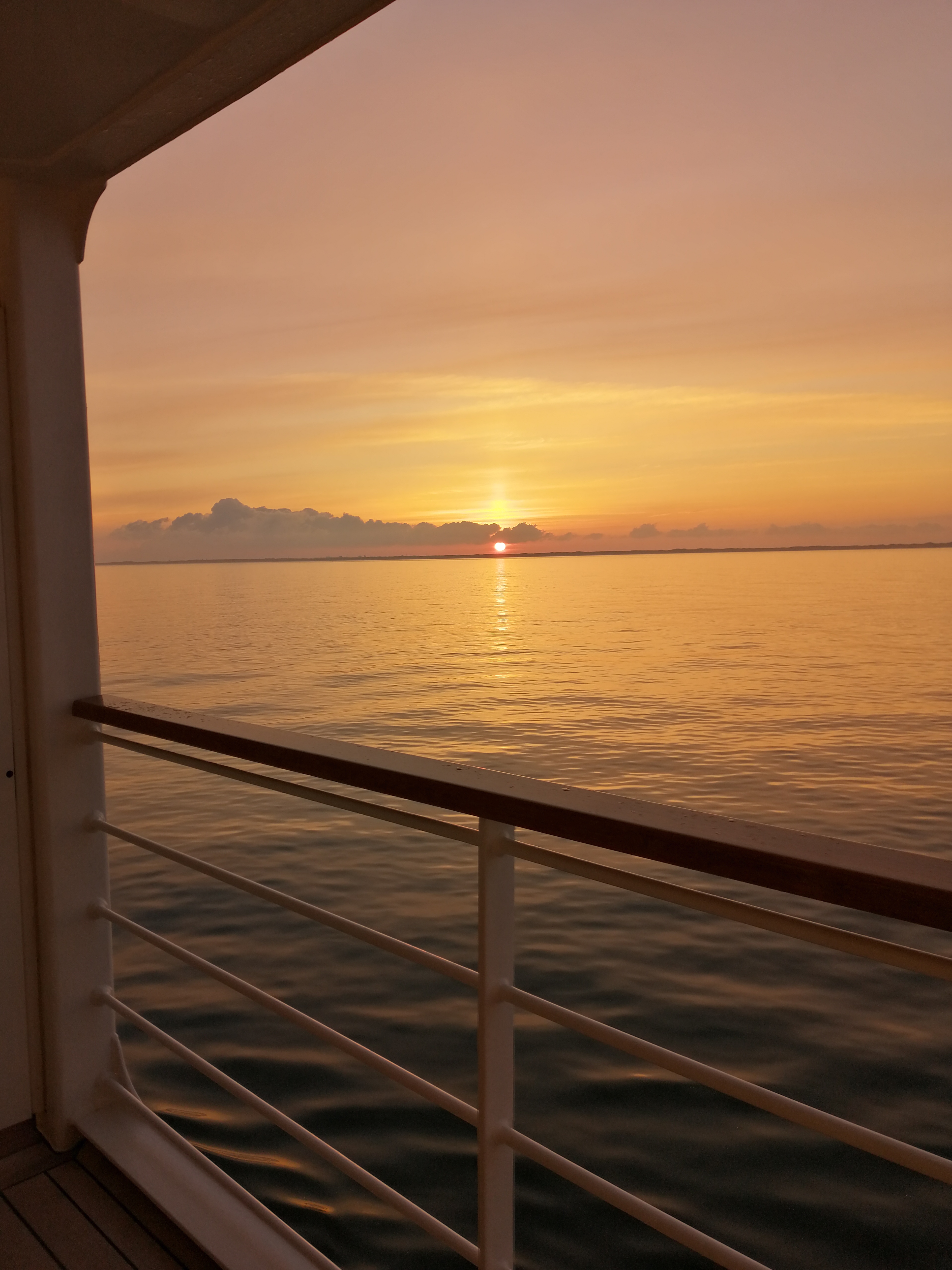 Sonnenuntergang über dem Ozean vom Kabinenbalkon eines Kreuzfahrtschiffs