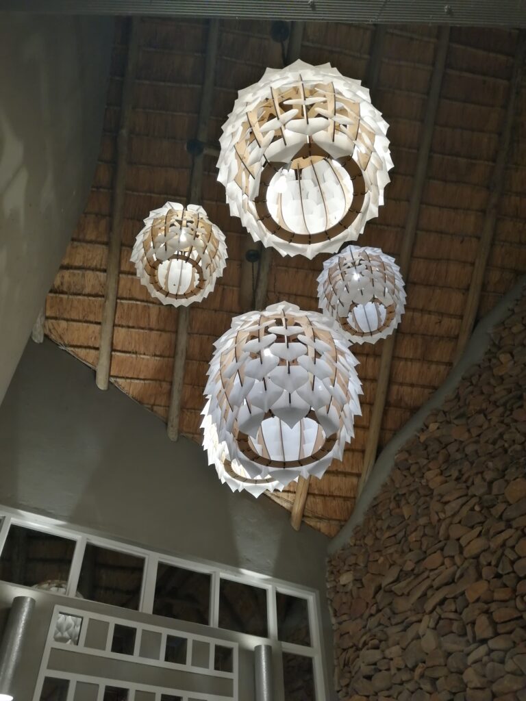 Stimmungsvolle Deckenlampen schaffen ein warmes und einladendes Ambiente in der Lodge in Südafrika – perfektes Design trifft auf natürliche Eleganz für unvergessliche Abende inmitten der afrikanischen Wildnis.