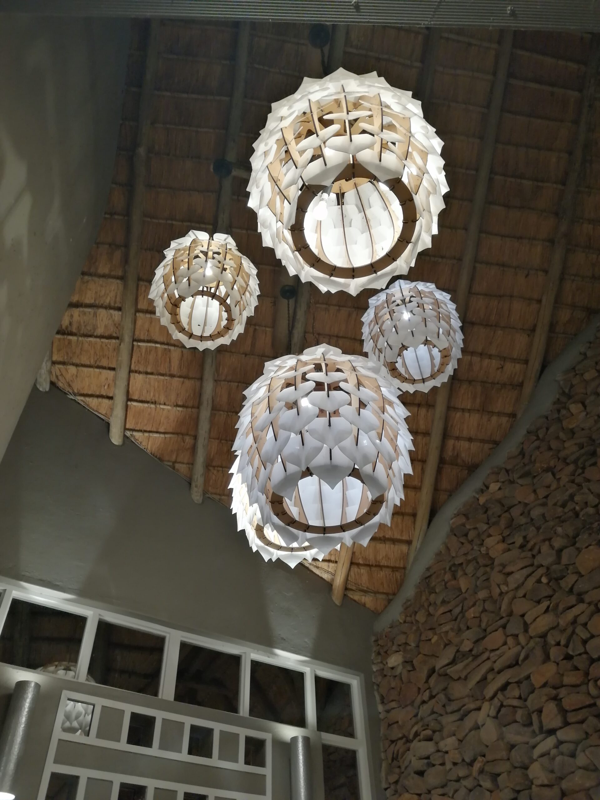 Luxuriöse Safari-Lodge mit geflochtenen Hängeleuchten und Strohdach in Südafrika