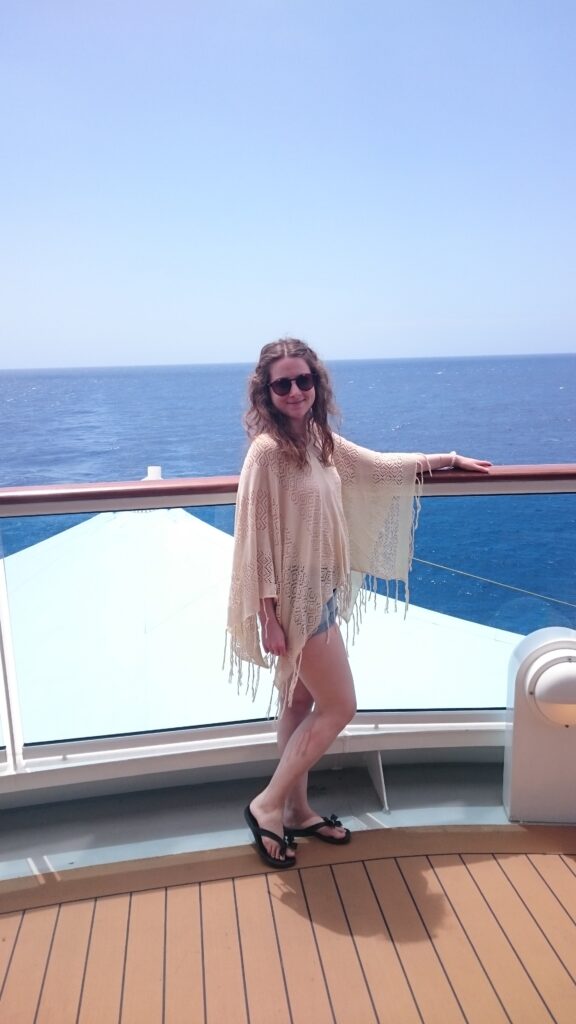 Larissa an der Reling eines Kreuzfahrtschiffs mit Blick auf das offene Meer