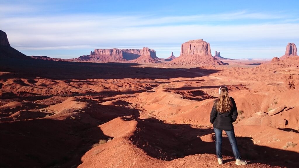 Panorama des Monument Valley mit roten Sandsteinbuttes und Larissa Wolfram-Kuhl im Vordergrund