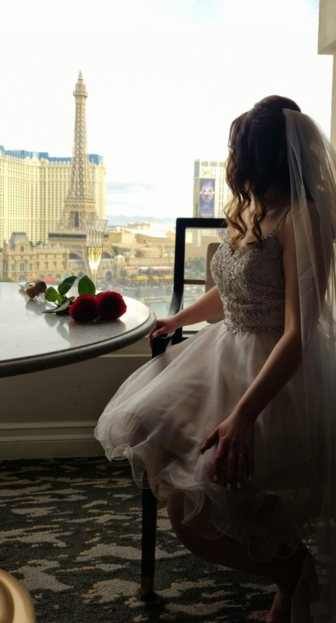 Larissa Wolfram-Kuhl im Brautkleid mit Frühstückstablett vor Hotelfenster mit Blick auf den Eiffelturm in Las Vegas, Vegas Bride
