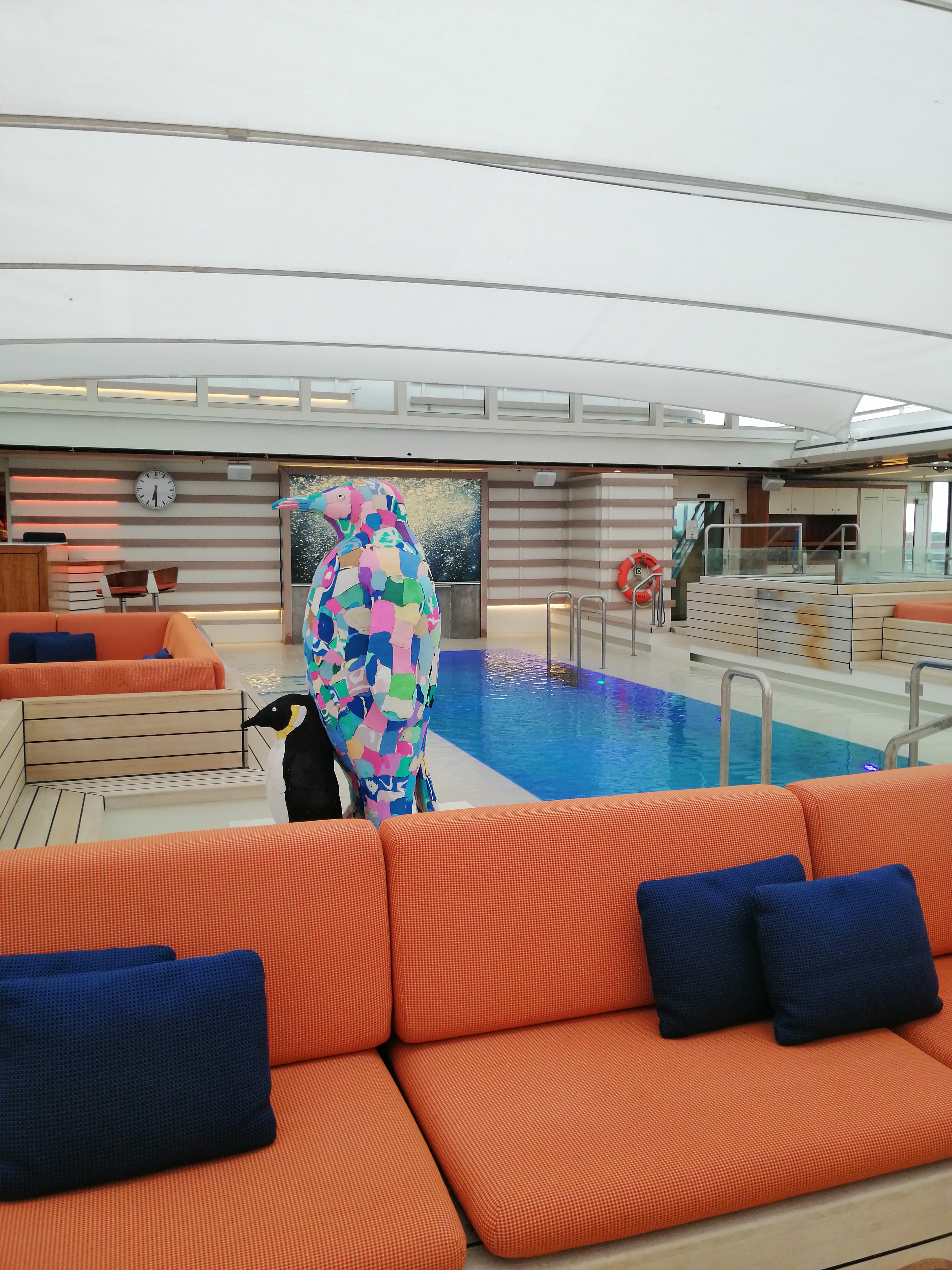 Lounge-Bereich mit orangefarbenen Sofas auf einem modernen Kreuzfahrtschiff