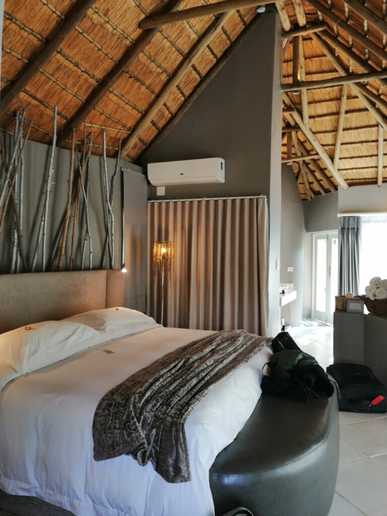 Modernes Safari-Schlafzimmer mit Strohdach und minimalistischem Design in Südafrika