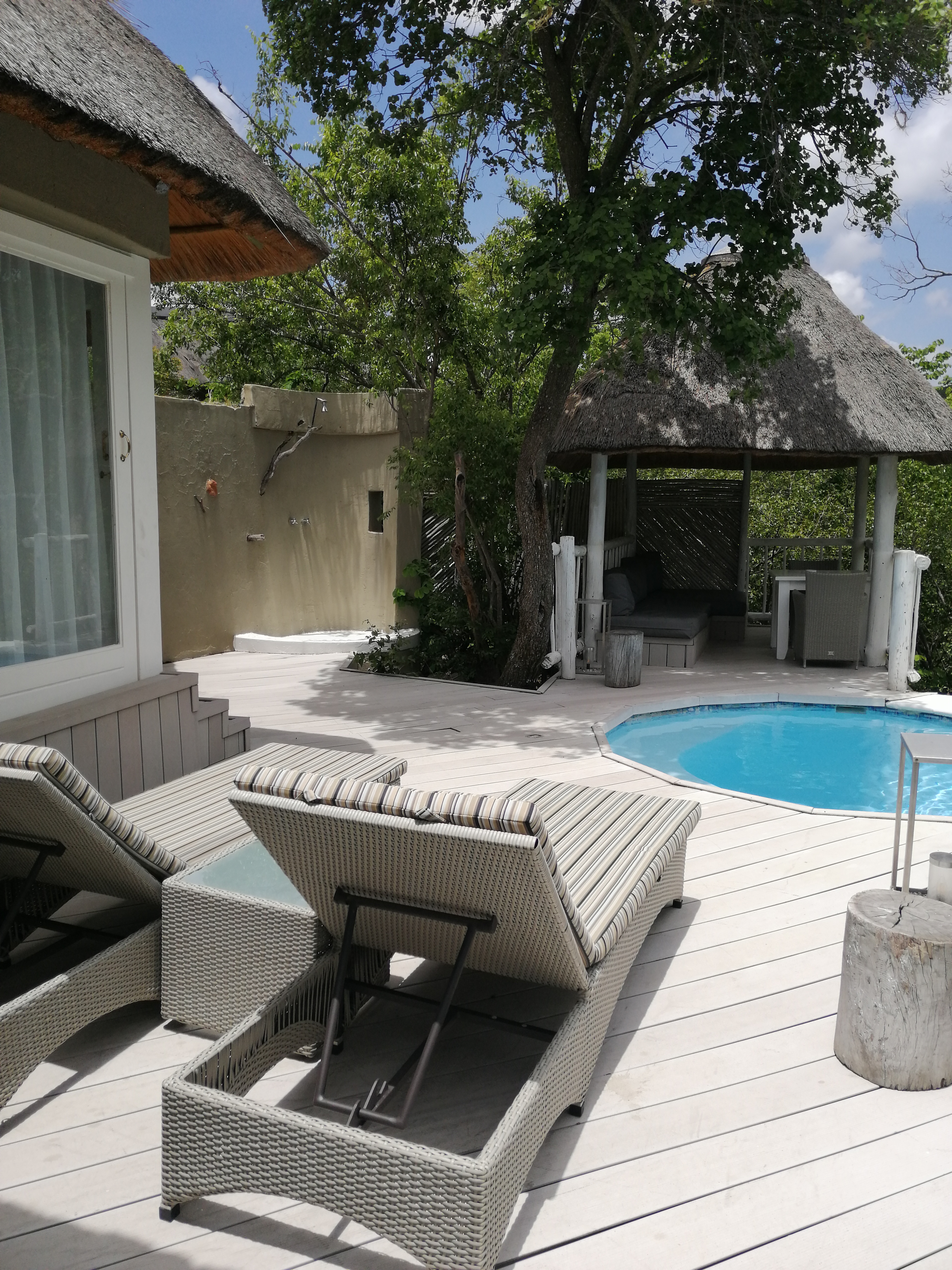 Private Poolterrasse mit Sonnenliegen an einer Safari-Villa in Südafrika