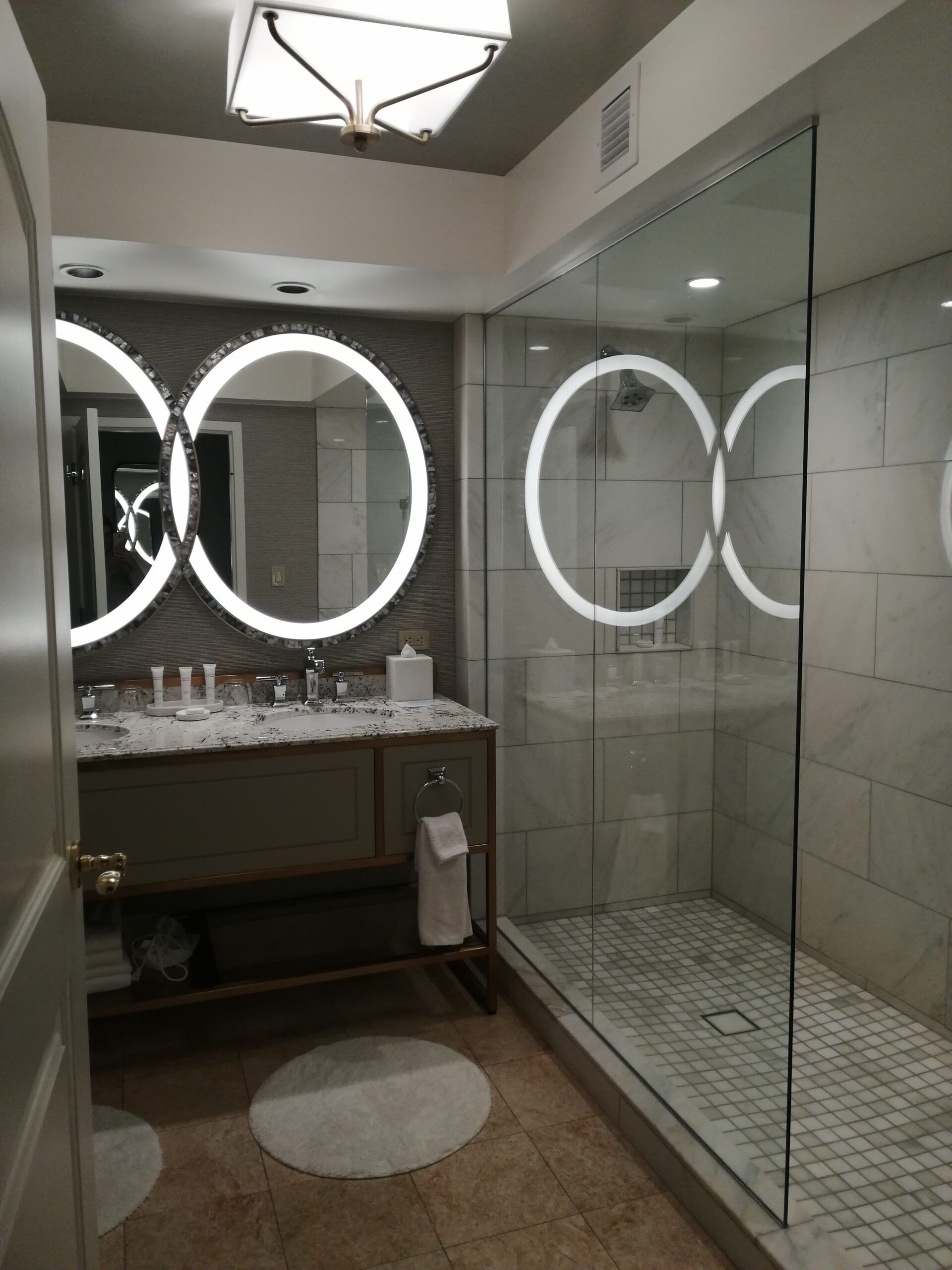 Modernes Hotelbad mit beleuchteten Spiegeln und Glasdusche in Las Vegas