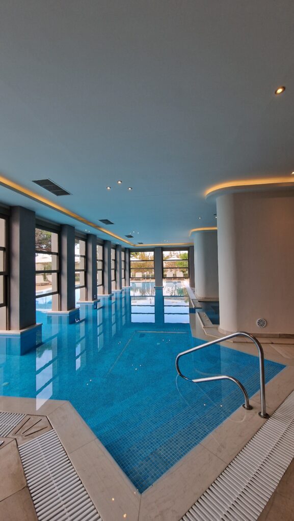 Indoorpool mit indirekter Beleuchtung, Innenpool mit modernen Säulen und warmem Licht