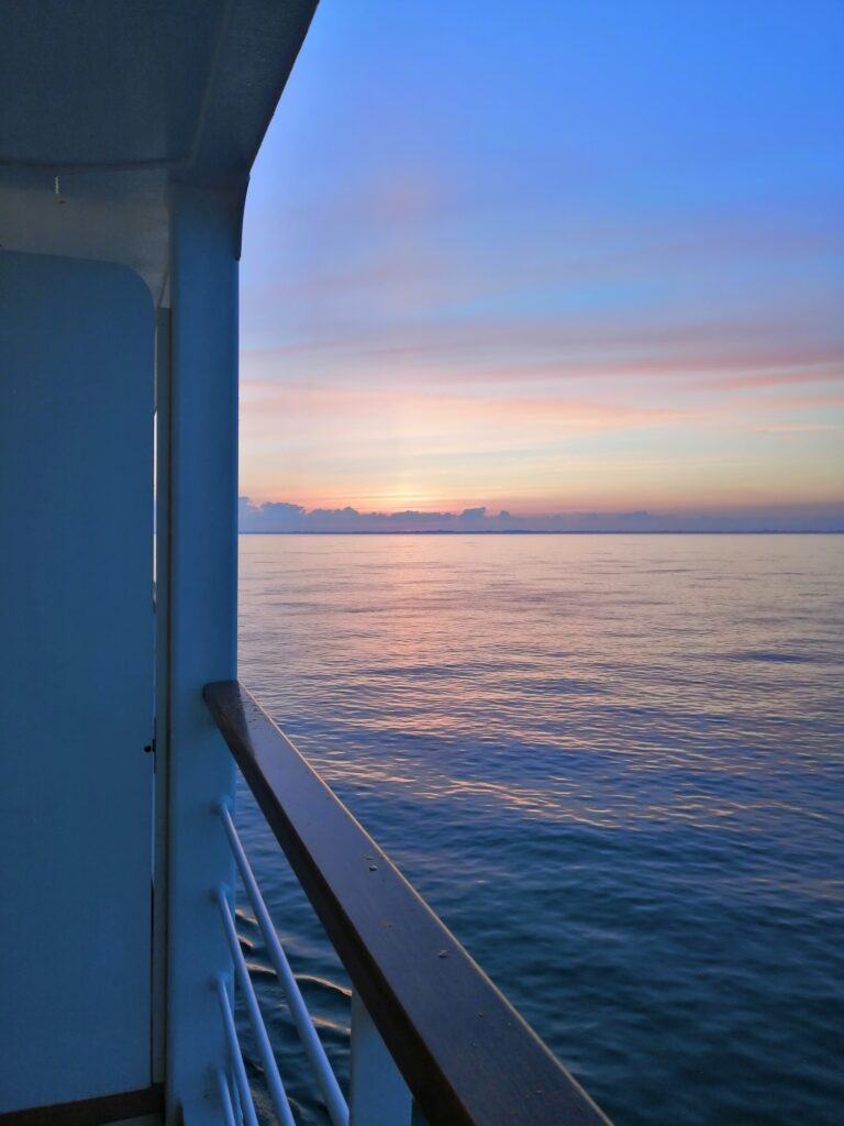 Sonnenaufgang vom Balkon eines Kreuzfahrtschiffes mit Meer