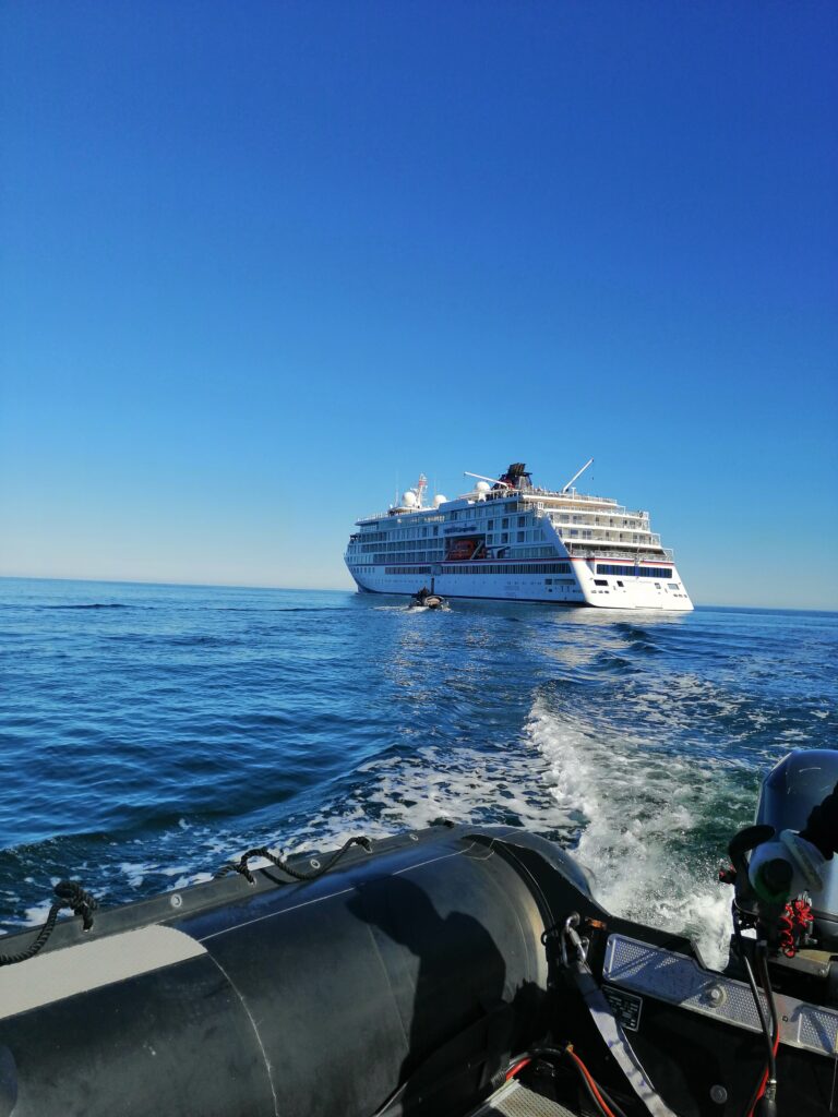 Zodiac mit Kurs auf Expeditionsschiff auf dem Meer