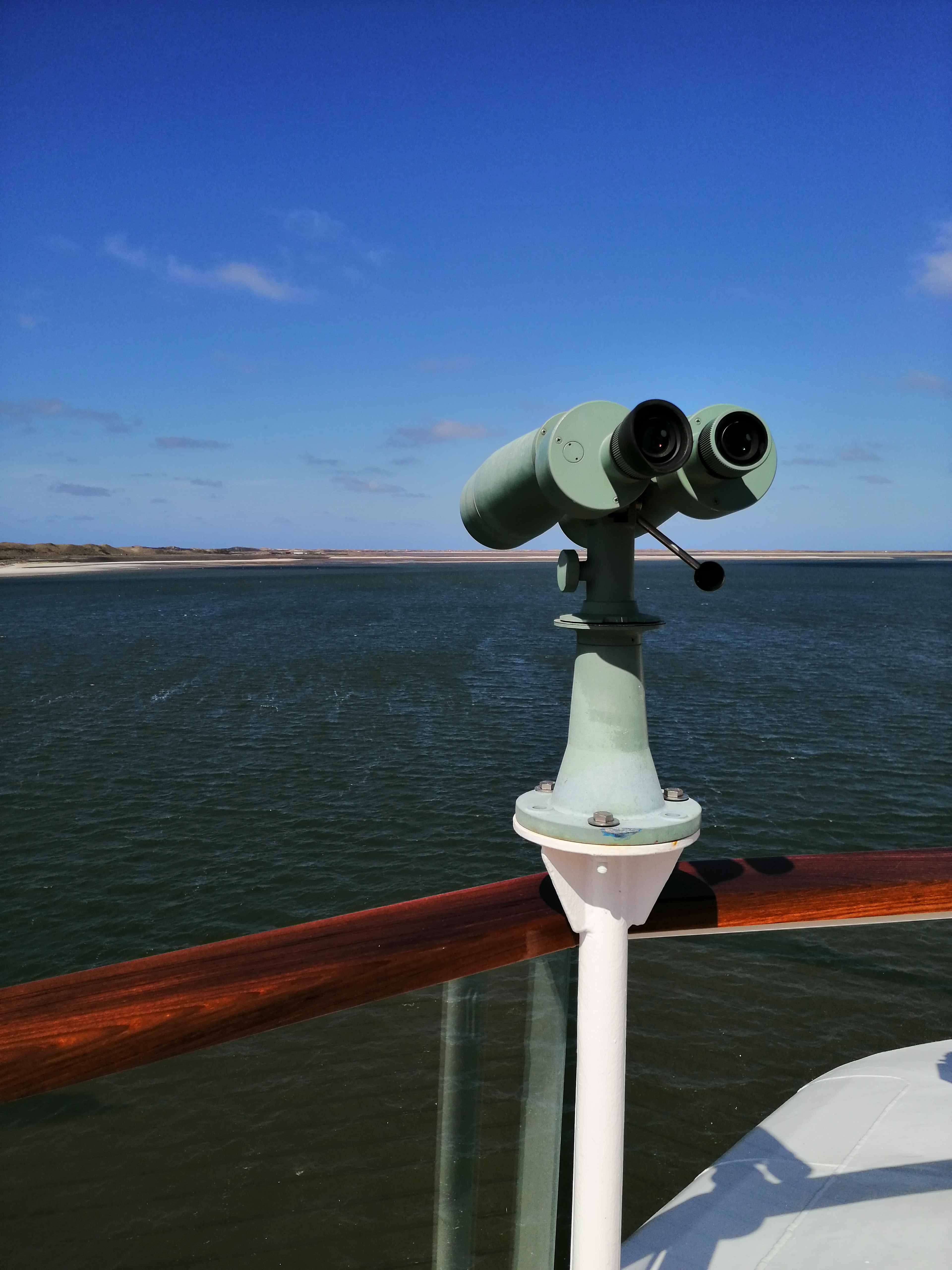 Fernglas auf Kreuzfahrtschiff mit Wasser im Hintergrund
