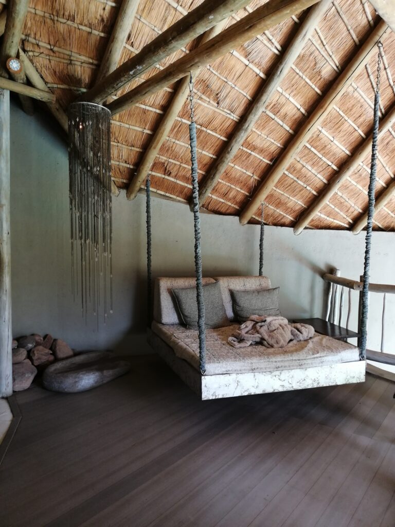 Hängeliege als Rückzugsort im afrikanischen Stil, Offenes Schlafzimmer mit Holzdach