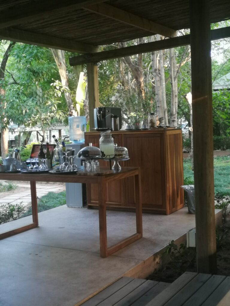 Teatime im Freien, Frühstückstisch auf Terrasse im Dschungel mit Geschirr und Blick ins Grüne