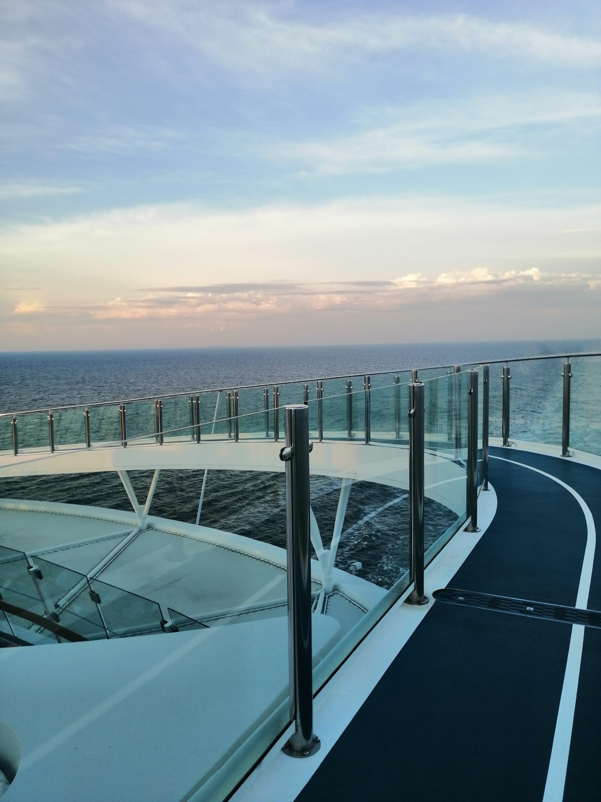 Designlaufstrecke auf Kreuzfahrtschiff mit Blick aufs Meer und Glasgeländer