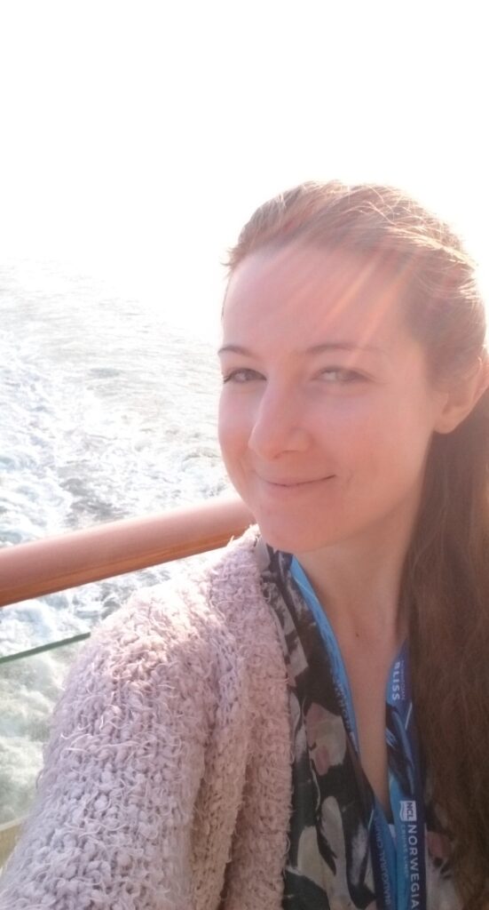 Larissa Wolfram-Kuhl auf Kreuzfahrtdeck im Sonnenaufgang lächelt in die Kamera